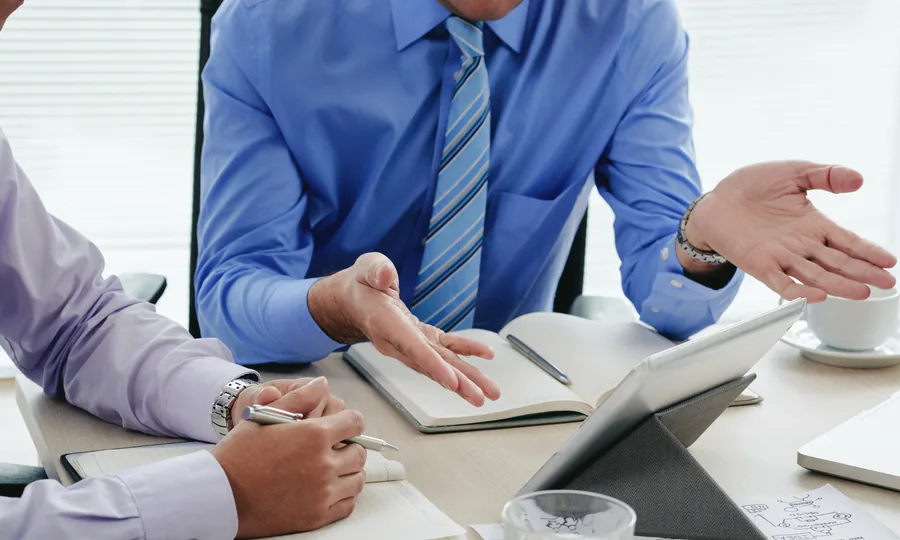 Advisers reviewing account-opening documents and a tablet with a client