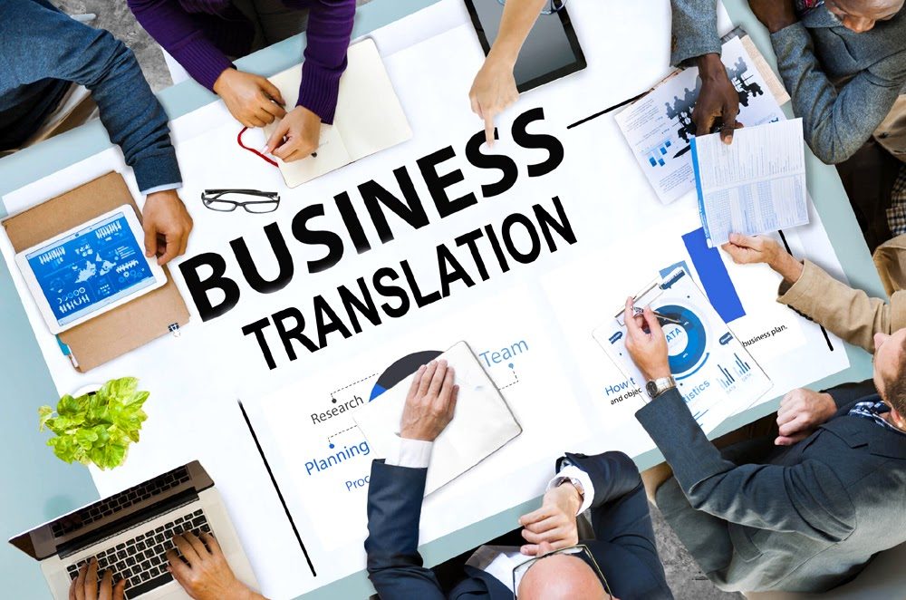 Business translation lettering on a meeting table covered with reports, charts, a tablet and a laptop
