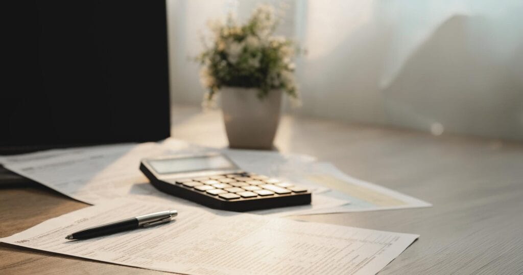 Personal income tax calculations and withholding paperwork on a desk